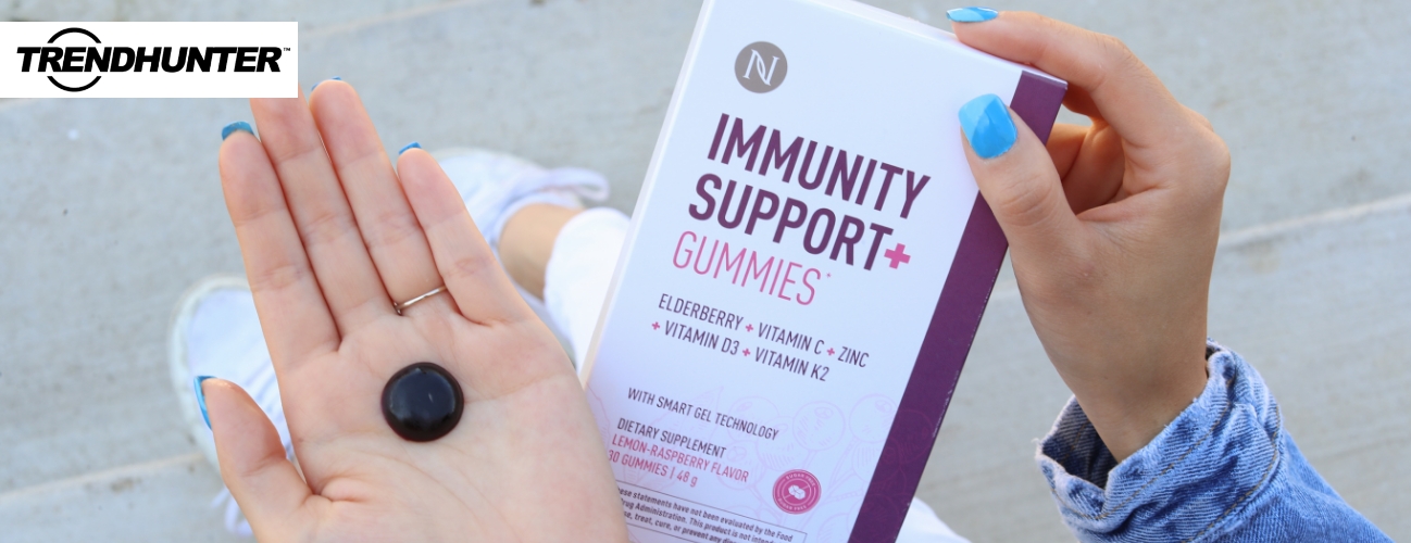 Image of a woman holding an Immunity Support + Gummy in one hand the product packaging in the other.